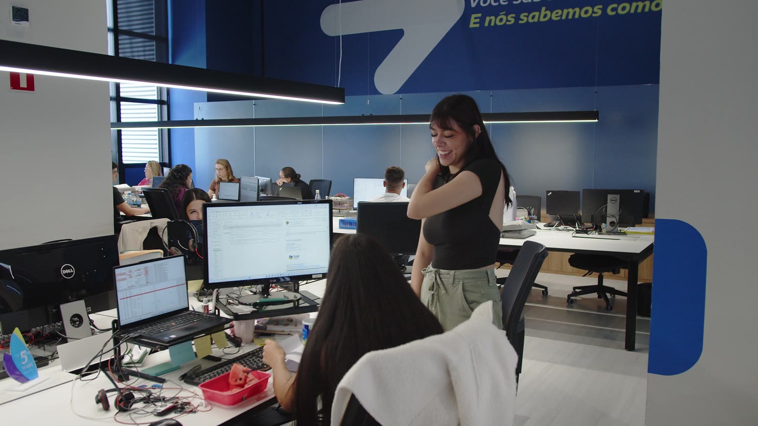 Escritório da Asia Shipping, com a parede da marca ao fundo