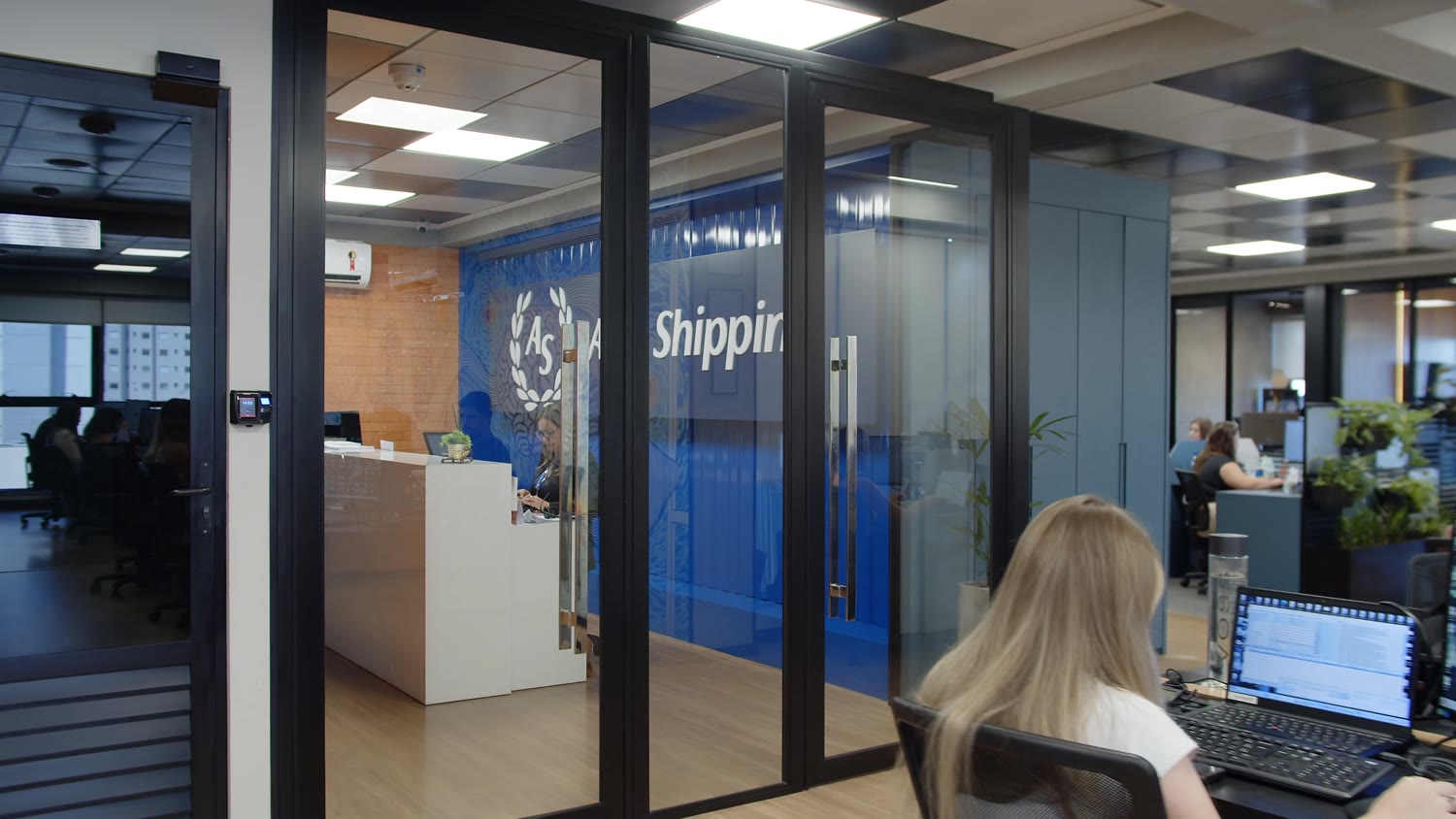Corredor envidraçado, com a marca na parede ao fundo