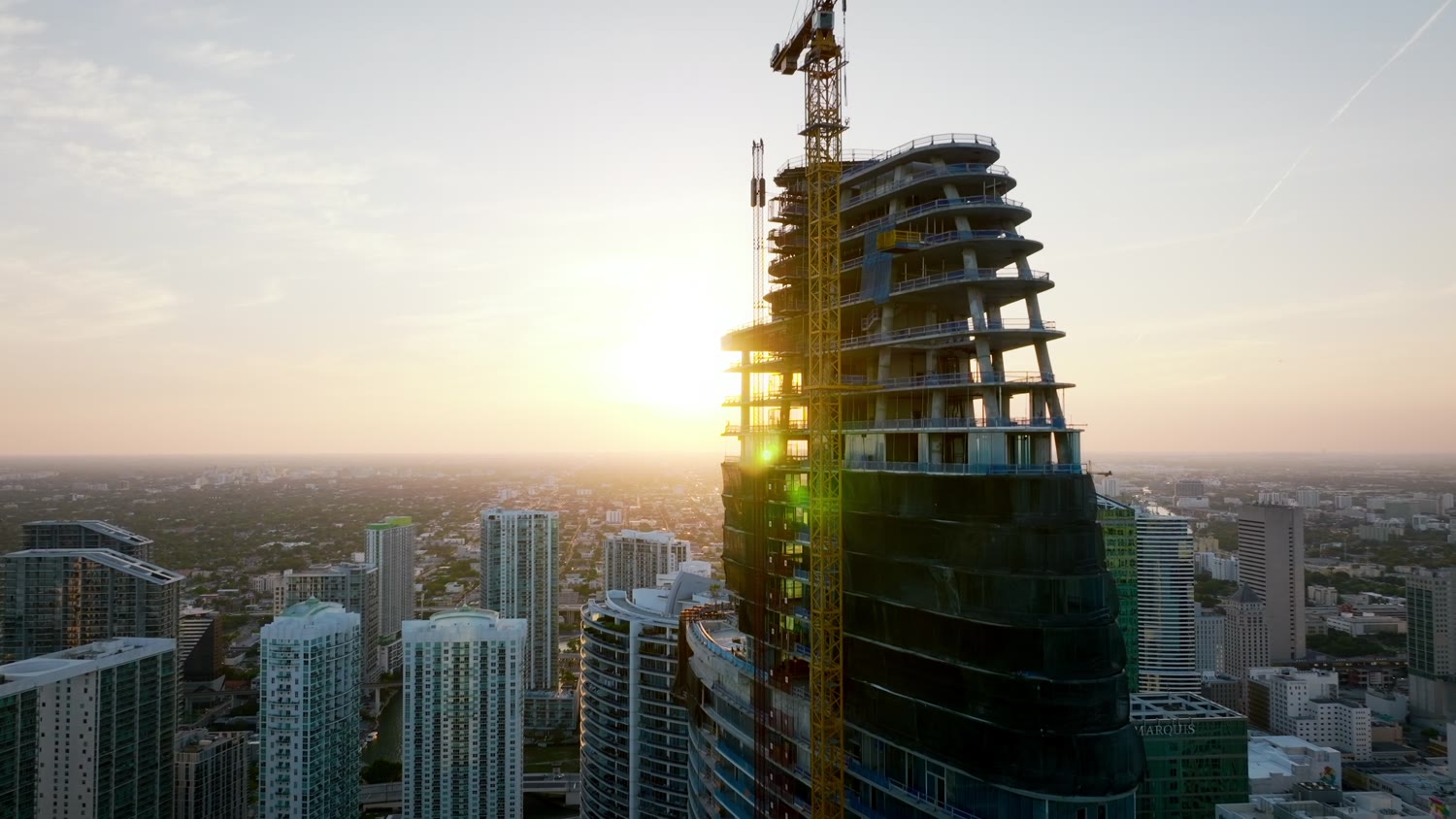 Edifício em obras contra o sol nascente