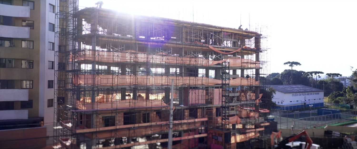 Prédio em construção com andaimes, ao fim da tarde