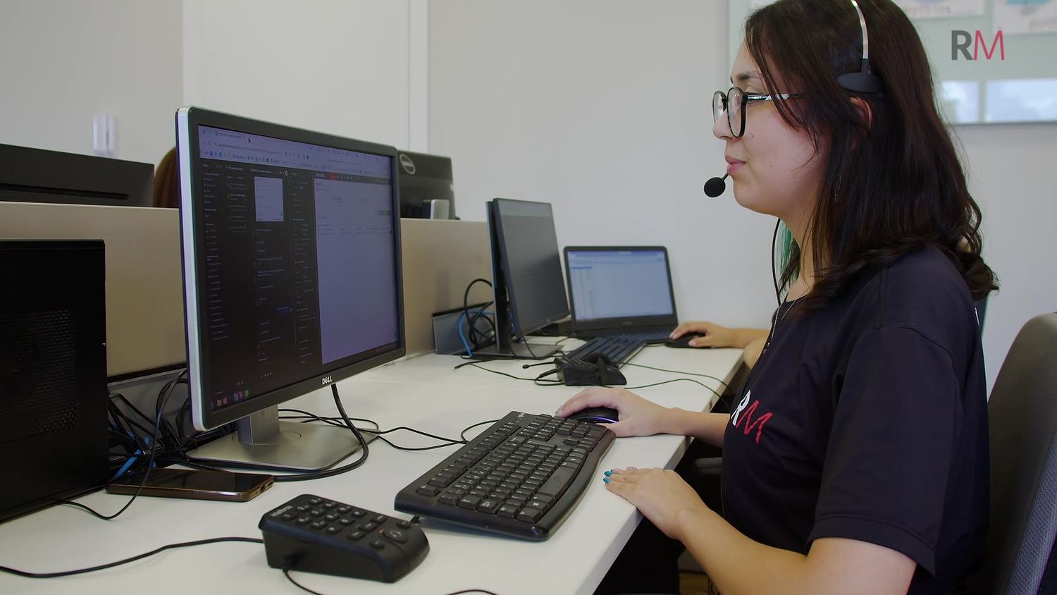 Analista de headset diante dos monitores