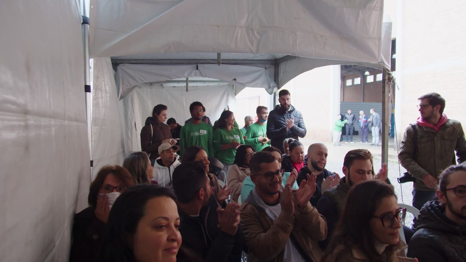 Plateia aplaudindo sob a tenda