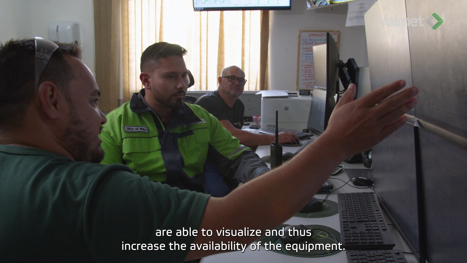 Operadores discutindo a operação na frente das telas