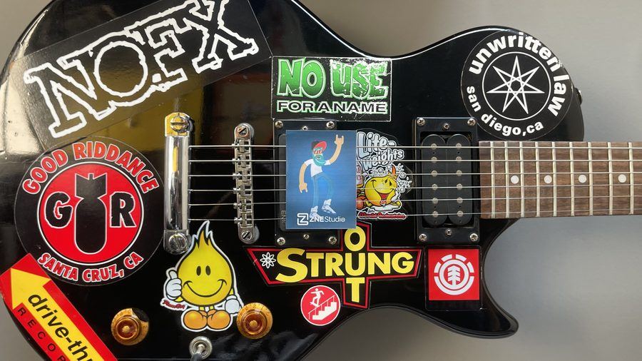 Na guitarra coberta de adesivos de banda